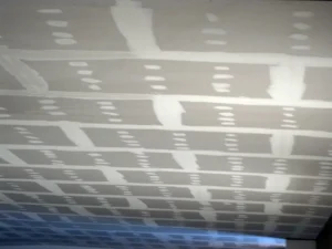 Comparativa visual entre un techo continuo de yeso laminado en un salón y un techo desmontable registrable en una oficina.